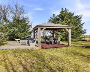 a gazebo with a table and chairs in a field at Tjarnarkot in Sandgerði