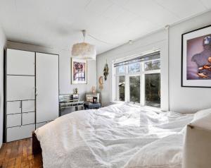 a bedroom with a white bed and a window at Tjarnarkot in Sandgerði