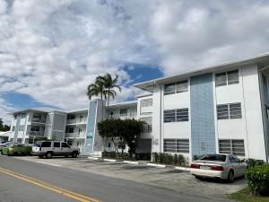 a parking lot with cars parked in front of a building at Bayview Regency Apartments By Lowkl in Fort Lauderdale
