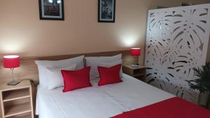 a bedroom with a white bed with two red pillows at Apart Saavedra in Concordia