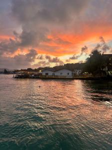 ein Sonnenuntergang über einem Gewässer mit einem Dock in der Unterkunft Hotel Cocotal in Isla Grande