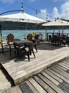 Ein Tisch, Stühle und Sonnenschirme auf einer Holzterrasse in der Unterkunft Hotel Cocotal in Isla Grande + 30 Fotos