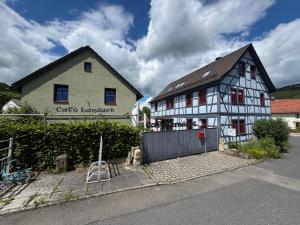 a white and black building with a gate in front of it at Café Landart im Thüringer Finistère in Plaue