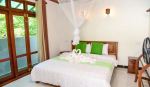 a bedroom with two beds with green and white at Zenora Villa ella in Ella