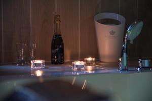 Una botella de vino sentada en el mostrador del baño con velas en Il Centro Short Lets, en Valguarnera Caropepe