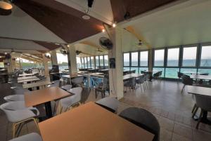 a restaurant with tables and chairs and the ocean at Appartement ALYA in Les Trois-Îlets +5 photos