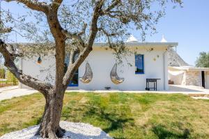 a house with a tree in front of it at Trulli boutique & suite in Santa Lucia