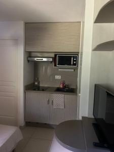a kitchen with a microwave and a table in a room at Le petit studio du Gard in Remoulins