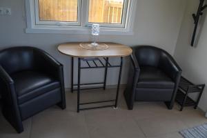 two black chairs and a table and two chairs at Hvammur 6 with private hot tub in Hafnarhólmur +10 photos