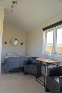 a bedroom with a bed and a table and chairs at Hvammur 6 with private hot tub in Hafnarhólmur