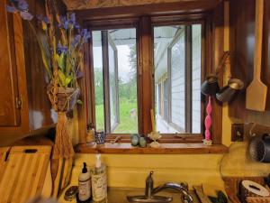 a kitchen with a window and a sink with flowers at Wine and roses farm house in Waymart +10 photos