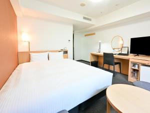 a hotel room with a large bed and a desk at Richmond Hotel Hakata Ekimae in Fukuoka