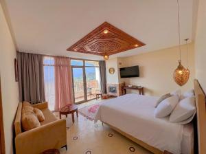 a bedroom with a bed and a couch and a tv at Oussoul House in Feddane Saïdi +62 photos