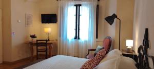 a bedroom with a bed and a desk and a window at Casa Becci Central Bright & Cozy Flat in San Gimignano