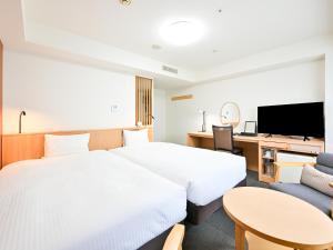 a hotel room with two beds and a tv at Richmond Hotel Hakata Ekimae in Fukuoka