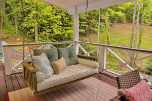 a porch swing with a couch on a porch at Dragonfly Cabin in Scaly Mountain