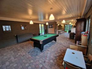 an empty room with a pool table in it at Authentic rural square farm in Poperinge