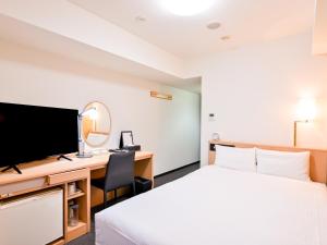 a hotel room with a bed and a desk and a tv at Richmond Hotel Hakata Ekimae in Fukuoka +42 photos