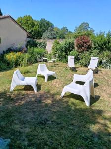 a group of white chairs sitting in the grass at Très belle chambre à Metz in Metz +5 photos