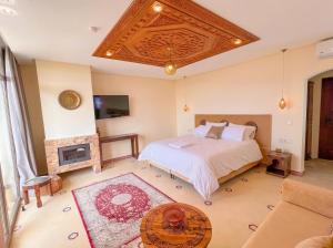 a bedroom with a bed and a fireplace at Oussoul House in Feddane Saïdi