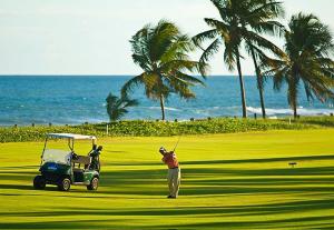 Un homme joue au golf avec une voiturette de golf dans l'établissement Iberostate - Mediterraneo BL4, à Praia do Forte