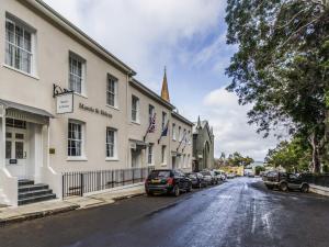 a street with cars parked in front of a building at Mantis St Helena in Jamestown