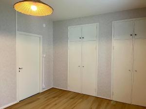 an empty room with white cabinets and wood floors at Spacious one room apartment in Vaasa