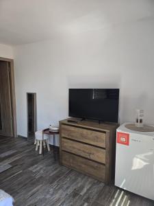 a living room with a flat screen tv on a wooden dresser at Casa Eva-Corbu in Corbu +15 photos