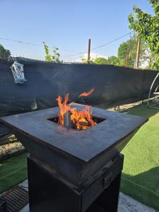 a stone fire pit in a yard with flames at Casa Eva-Corbu in Corbu