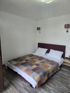 a bedroom with a bed with a quilt on it at Casa Eva-Corbu in Corbu