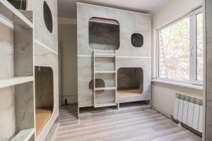 a room with a wall with shelves and a window at Arch Hostel in Almaty
