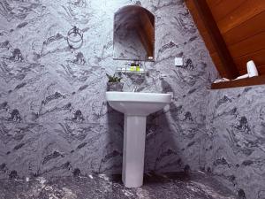 a bathroom with a sink and a marble wall at Rainforest Emerald Haven in Deniyaya +18 photos