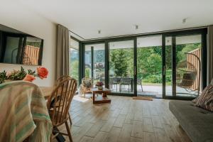 a living room with sliding glass doors and a table at Domki Tymianek & Melisa in Kościelisko