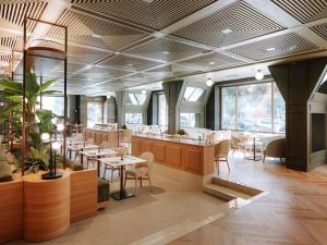 a restaurant with tables and chairs in a room at Mövenpick Hotel Bari in Bari