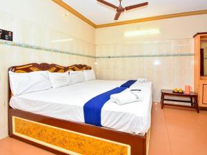 a bedroom with a bed with white and blue sheets at SNN Residency in Rāmeswaram