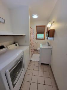 a small kitchen with a sink and a dishwasher at Beach House with Spacious Deck for Entertaining in Narragansett +20 photos