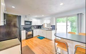 a kitchen with white cabinets and a black refrigerator at Beach House with Spacious Deck for Entertaining in Narragansett