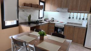 a kitchen with a wooden table and chairs and a kitchen with a table at Apart Saavedra in Concordia +26 photos