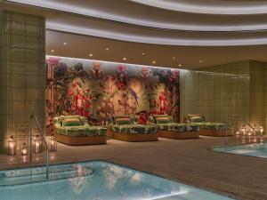 a hotel lobby with a swimming pool and a mural at Faena New York in New York