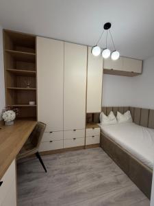 a bedroom with a bed and a desk and a bed and cabinets at Urban Elegance in Cluj-Napoca