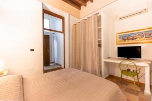 a bedroom with a bed and a tv and a window at Via Roma Rooms Guesthouse in Sassari +30 photos