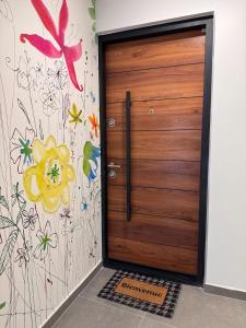 a wooden door in a room with flowers on the wall at 101 - Centre de voiron in Voiron
