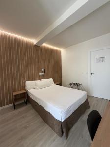 a bedroom with a large bed and a wooden wall at Hotel Victoria Centro in Almuñécar