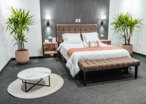 a bedroom with a large bed and two potted plants at El Portal Del Marques in Cajamarca +53 photos