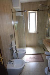 a bathroom with a shower and a toilet and a sink at Joni s Guest House in Krujë +52 photos