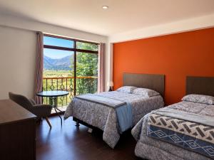 a hotel room with two beds and a window at Qantu casa Boutique in Calca