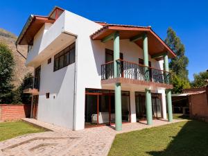 a white house with a balcony at Qantu casa Boutique in Calca