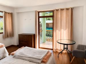 a bedroom with a bed and a table and a window at Qantu casa Boutique in Calca