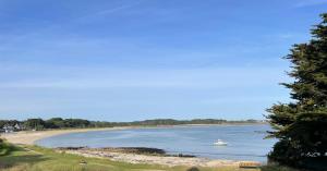 a boat in the water next to a beach at Chambre à louer face a la plage de Beaumer in Carnac