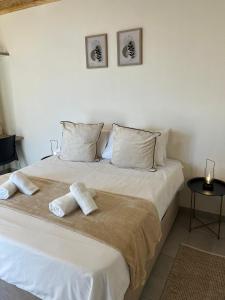 a bedroom with a white bed with two pillows on it at Windy Dunes Self -Catering Accommodation, Luderitz in Lüderitz